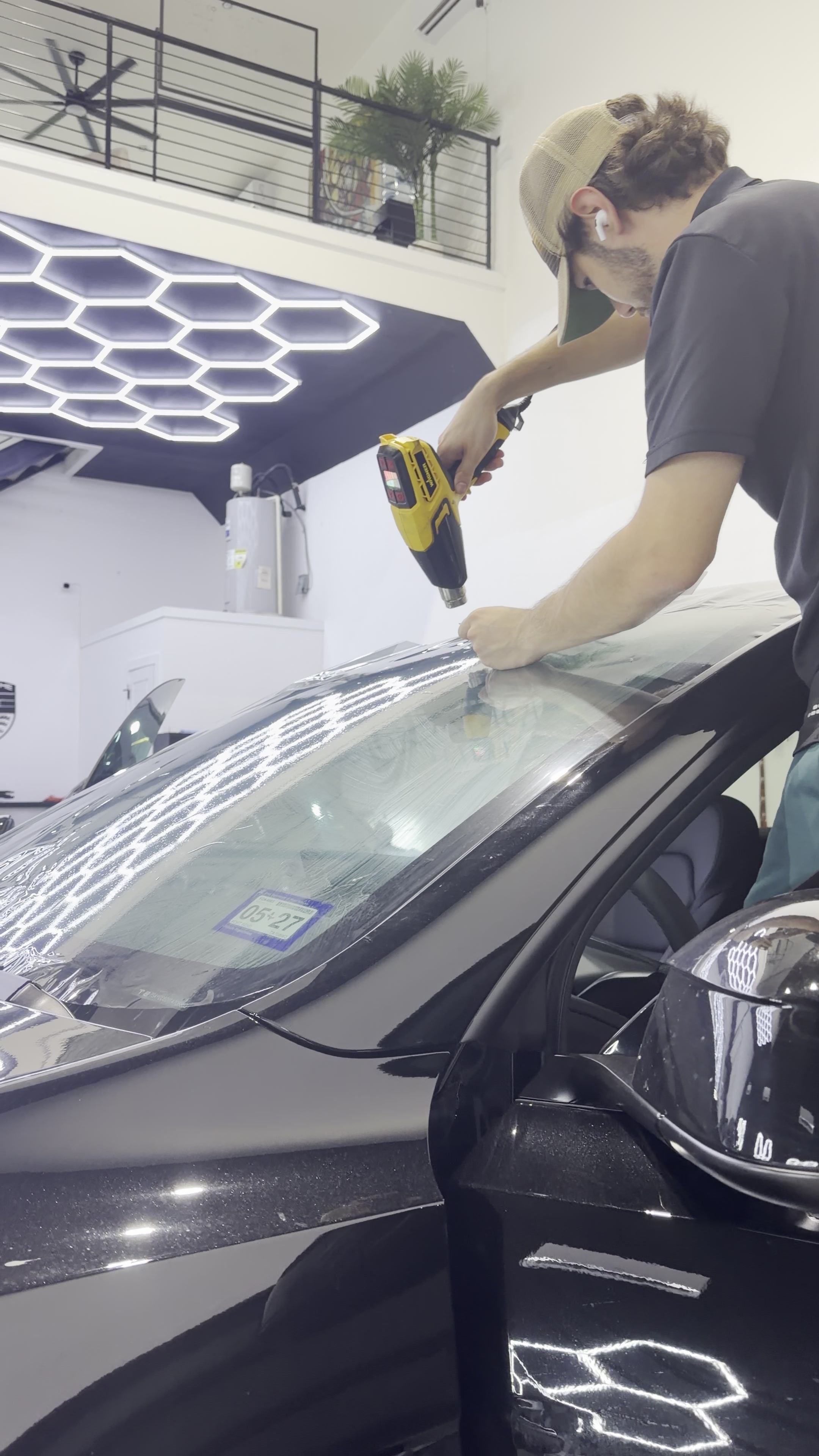 Technician shaping window film over a windshield