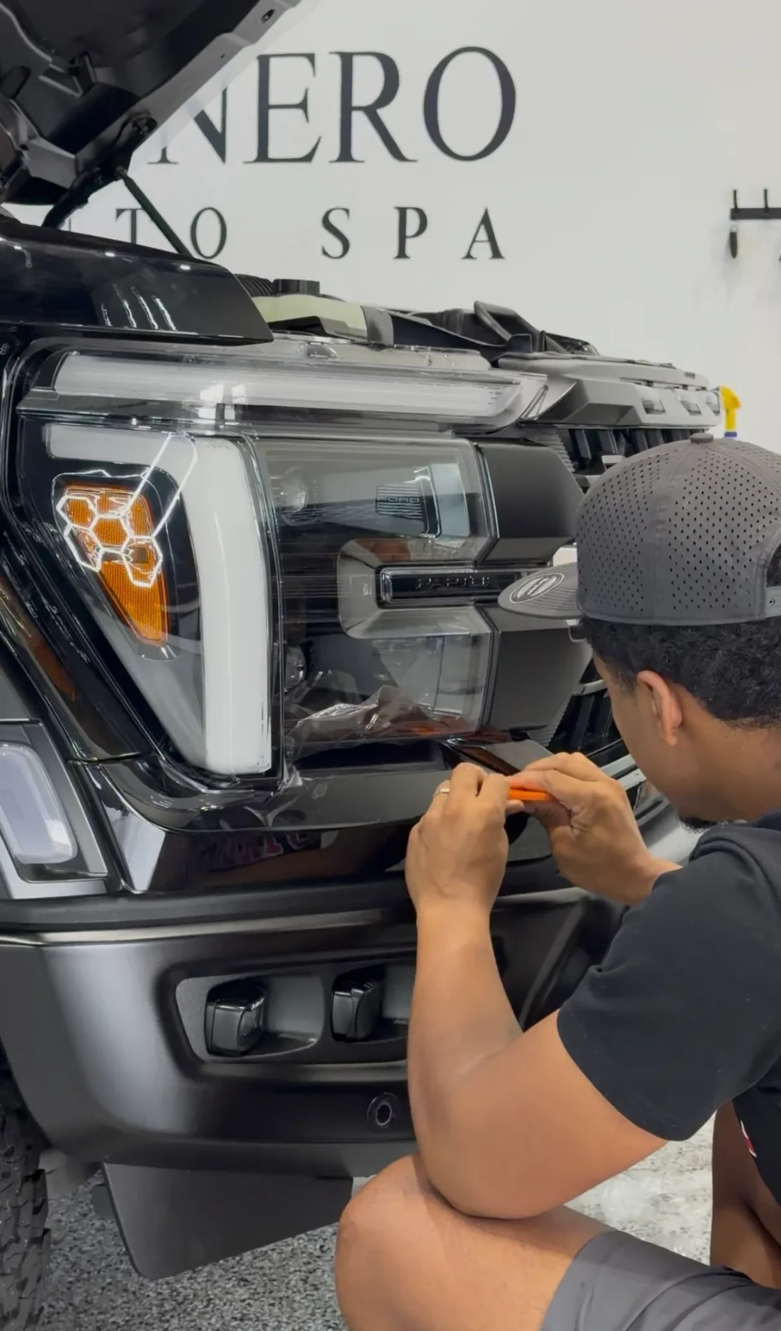 Huracán Nero technician fitting PPF to the front of a Hummer EV
