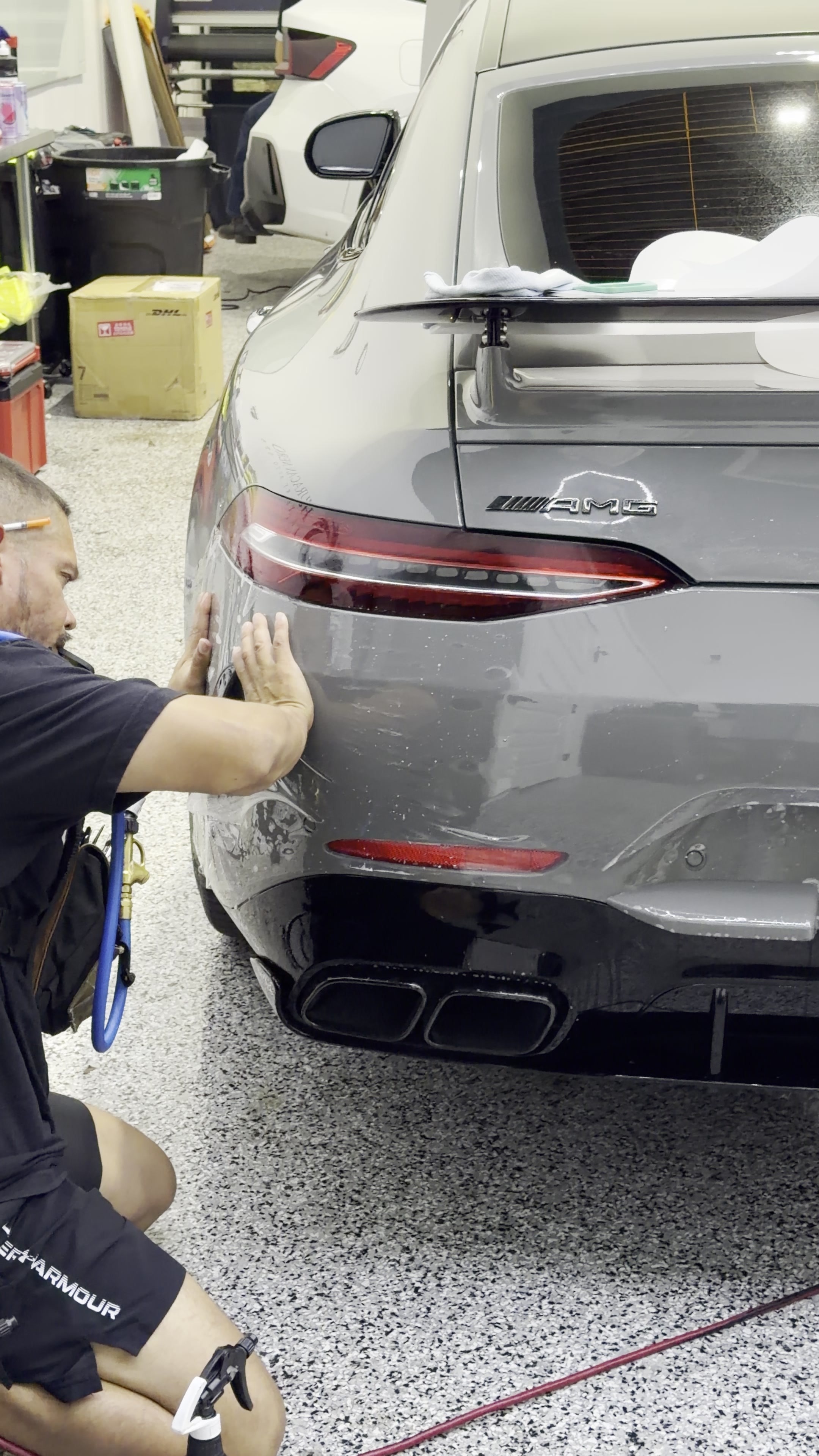 PPF being smoothed over the rear of a silver Mercedes
