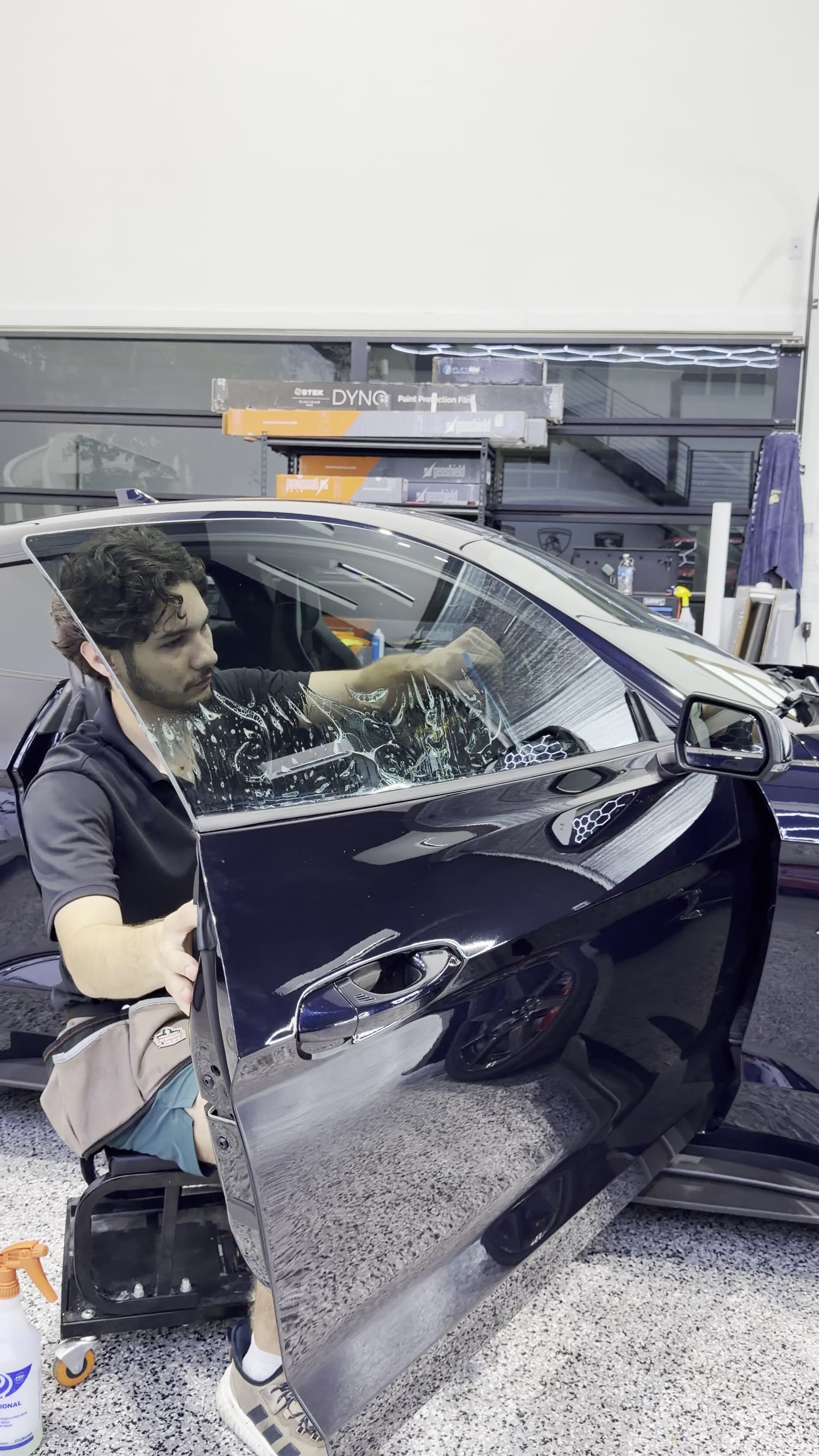 Huracán Nero technician installing window tint on a customer vehicle