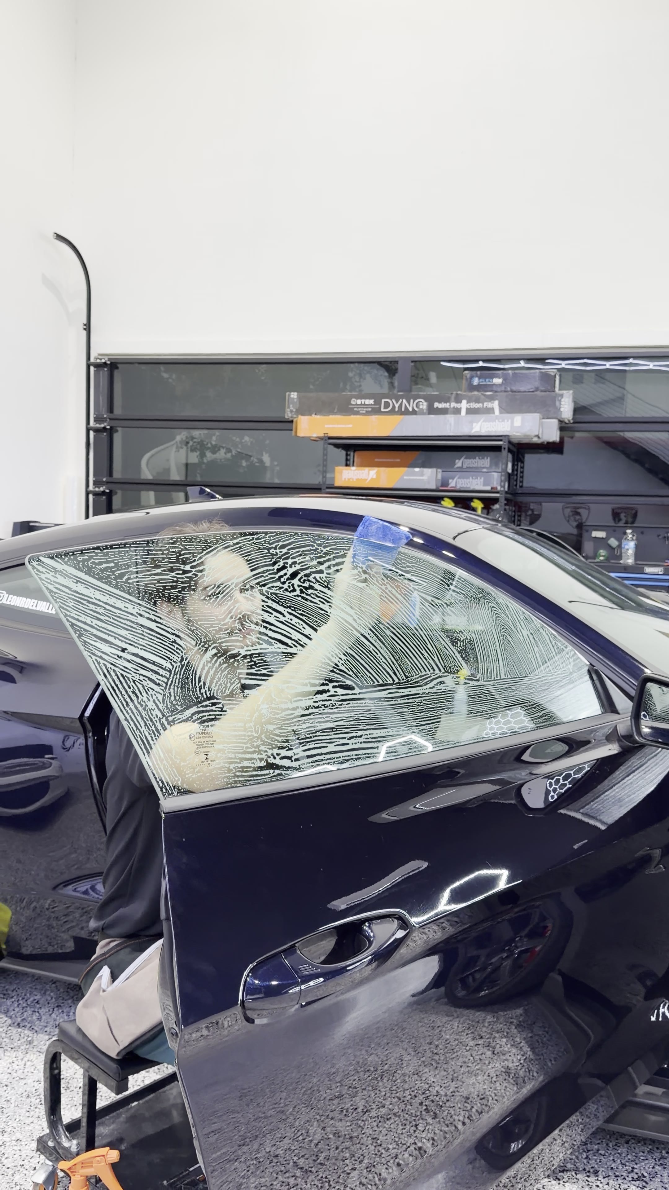 Window film installation on the side glass of a dark vehicle